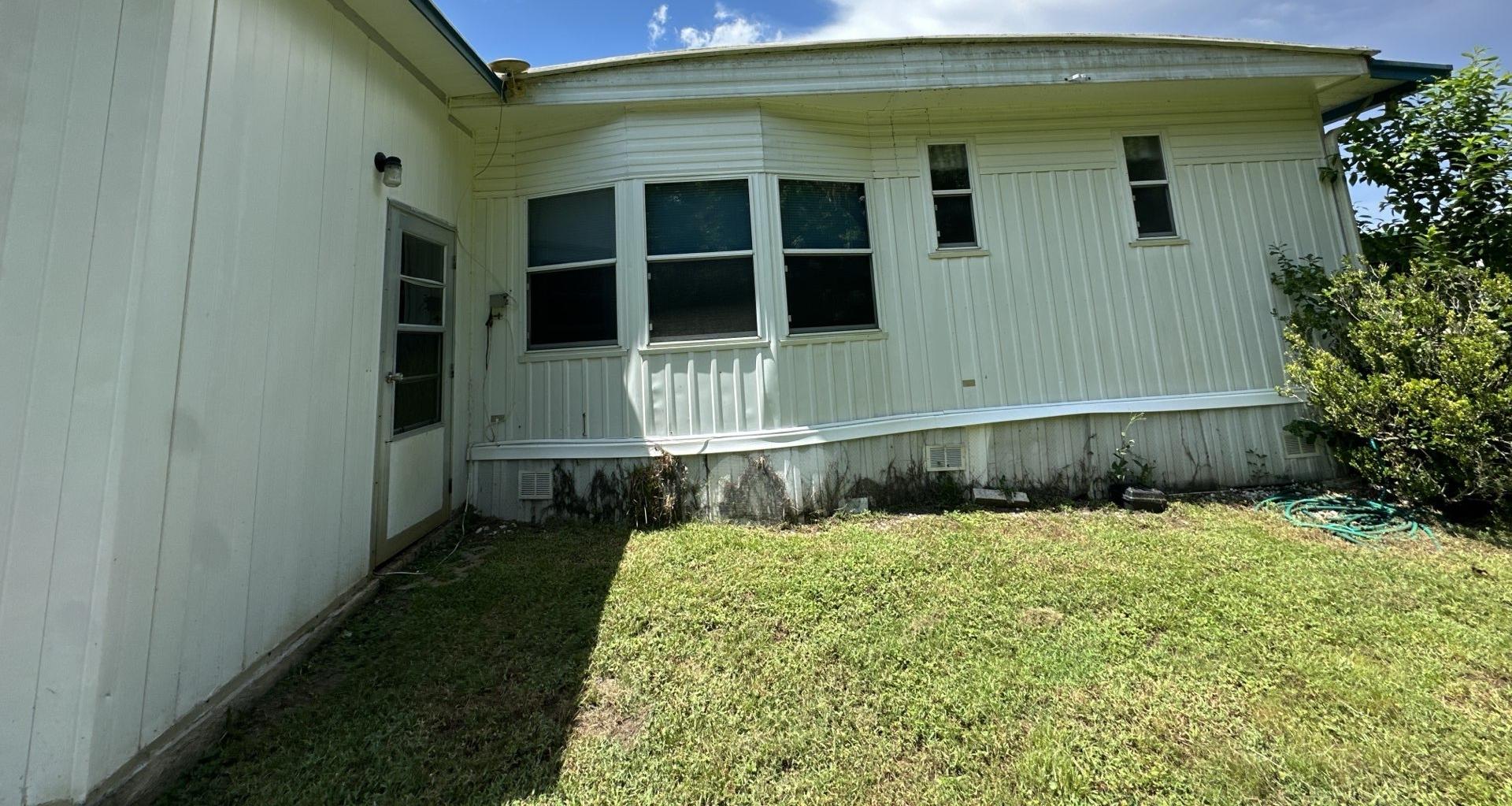 Back of a manufactured home in Dade City FL before its roof replacement