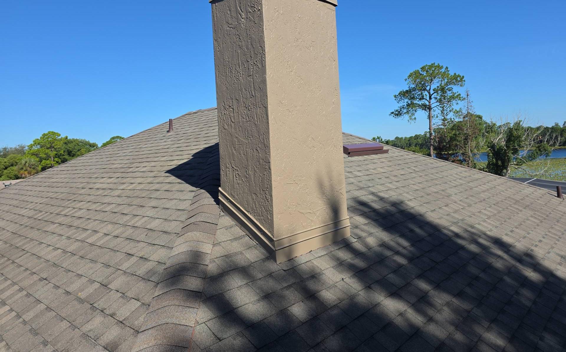 New TAMKO Titan XT shingles and chimney flashing with the lake behind in Deltona FL