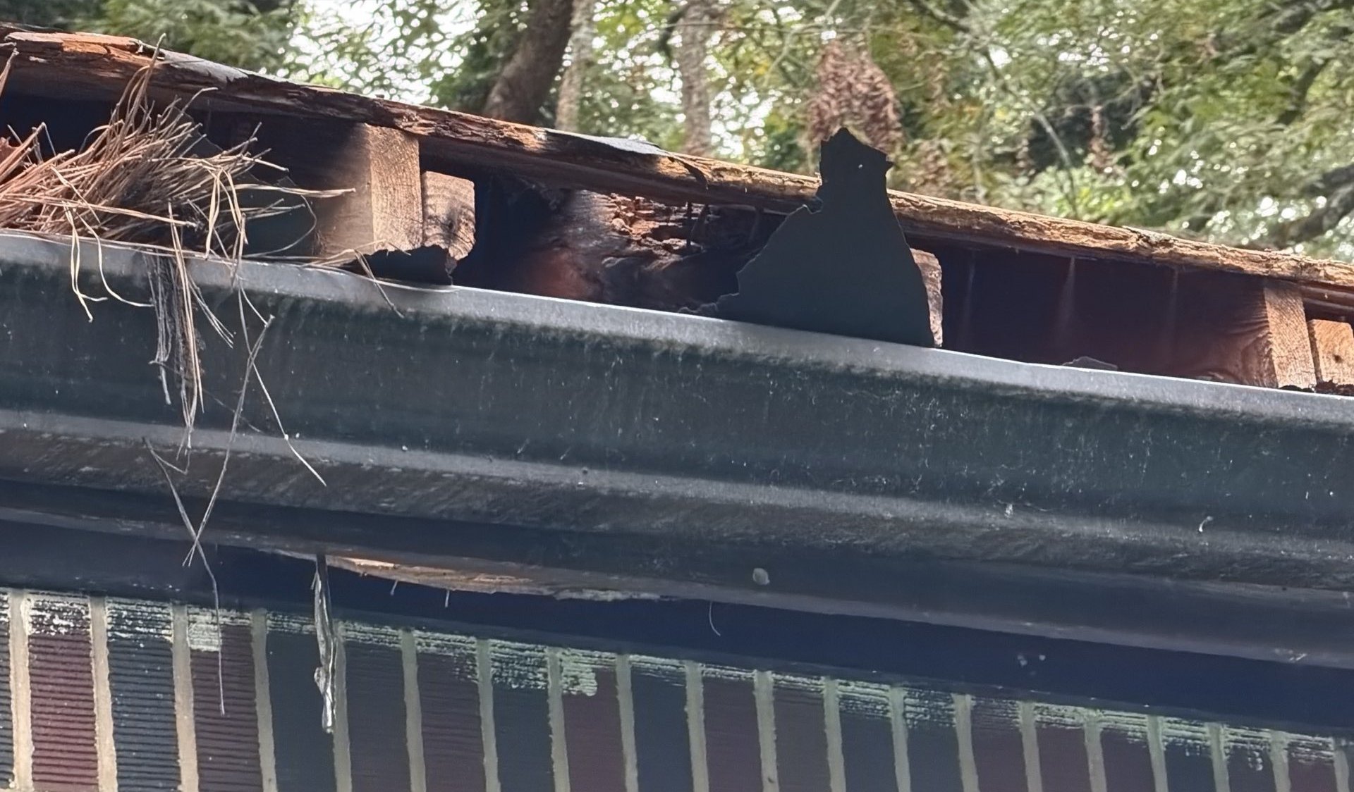 Broken decking behind the gutter where the tree hit a roof in Atlanta GA